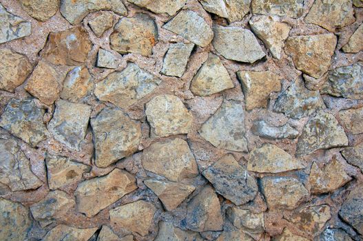 The wall of rough grey and brown sharp stones, summer, Portugal