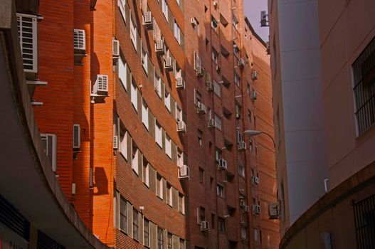 Orange brick building with concave wall, summer