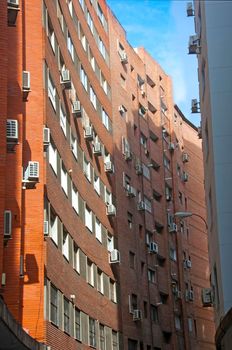 Orange brick building with concave wall, vertical view, summer
