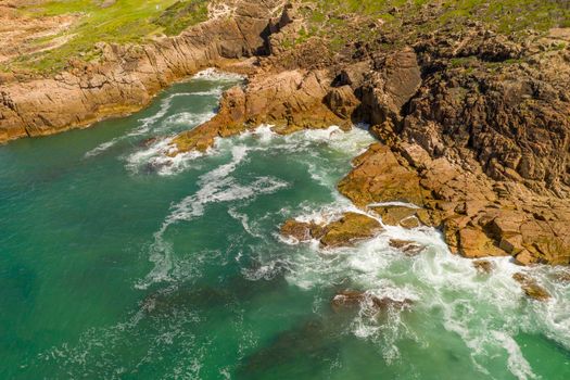 Aerial view of the brown Rocks and blue water of the Tasman Sea at Birubi Point near Port Stephens in regional New South Wales in Australia