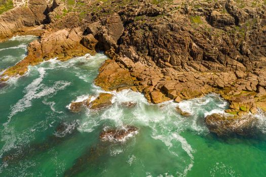 Aerial view of the brown Rocks and blue water of the Tasman Sea at Birubi Point near Port Stephens in regional New South Wales in Australia