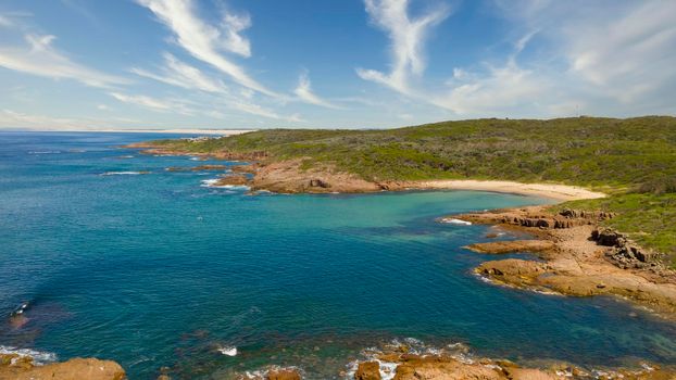 Aerial view of the brown Rocks and blue water of the Tasman Sea at Birubi Point near Port Stephens in regional New South Wales in Australia