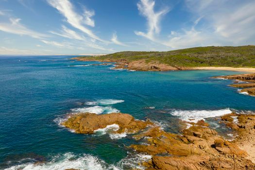 Aerial view of the brown Rocks and blue water of the Tasman Sea at Birubi Point near Port Stephens in regional New South Wales in Australia