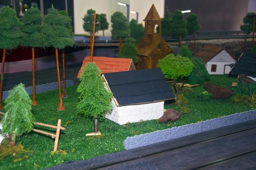 Small toy church, different houses and trees around, left down view