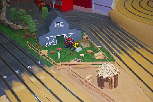 Small grey toy housestock, red tractor and wooden barn, left up view