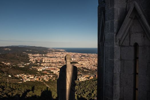 Wide angle view of the city of Barcelona (Catalonia, Spain) and surroundings from the rooftop terrace of the Expiatory Church of the Sacred Heart, on Mount Tibidabo. A majestic view shared with the statues of the Jesus's twelve apostles.