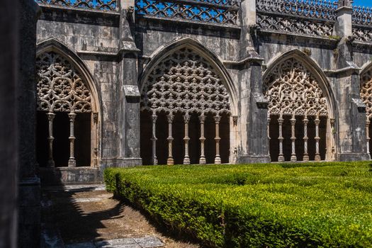 View of the richly decoration arches in the cloister hall of the Monastery of Batalha, a Dominican order convent located in the district of Leiria, in Portugal.