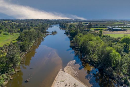 Aerial view of the Hawkesbury River running through agricultural farmland in regional New South Wales in Australia