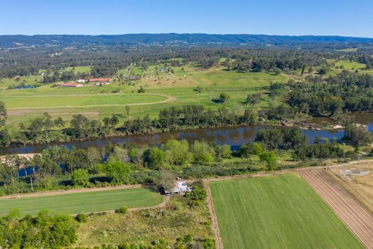 Aerial view of the Hawkesbury River running through agricultural farmland in regional New South Wales in Australia