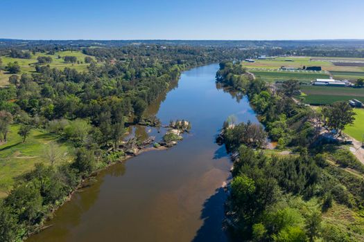 Aerial view of the Hawkesbury River running through agricultural farmland in regional New South Wales in Australia