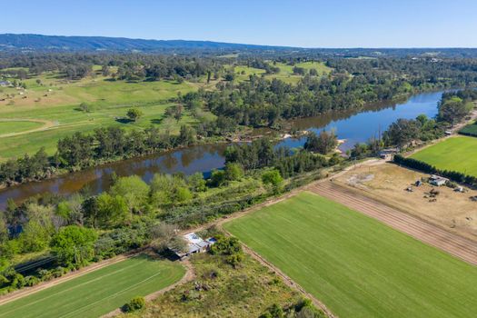 Aerial view of the Hawkesbury River running through agricultural farmland in regional New South Wales in Australia