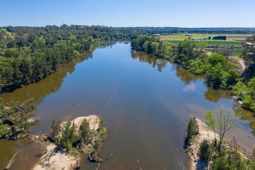 Aerial view of the Hawkesbury River running through agricultural farmland in regional New South Wales in Australia