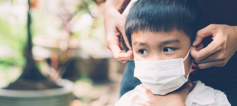 Mother take care son with face mask for protection disease flu or covid-19 outdoors, mom wearing on medical mask with child safety for protect outbreak of pandemic, medical concept, banner website.