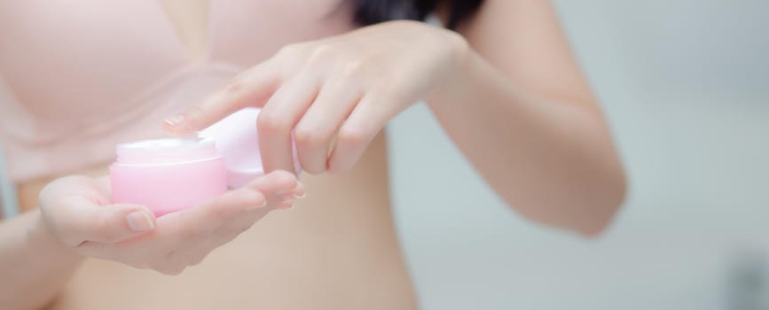 Closeup hand of young asian woman holding product cosmetic applying cream in jar, beautiful girl hand touch lotion, beauty perfect, treatment and skin care and health concept, banner website.