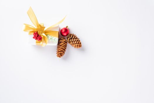 Christmas holiday composition top view flat lay of with a gift box and gold ribbon, fir branches, pine cones, and candy with copy space isolated on white background, New year day concept