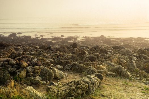 Sunrise light diffused by fog on the beach