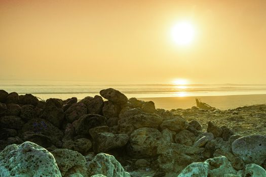 Sunrise light diffused by fog on the beach