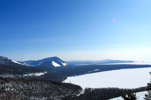 Baikal mountains in winter in snow. Forest in snow-covered mountains.