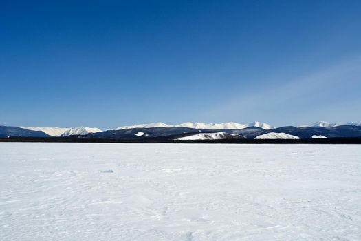 Baikal mountains in winter in snow. Forest in snow-covered mountains.