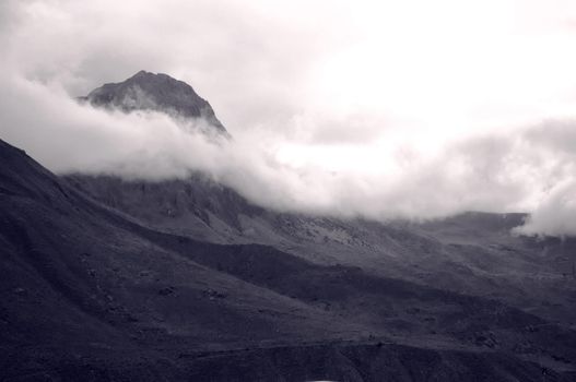 A massive peak emerges form the clouds in the Sacred Valley of the Incas, Peru.