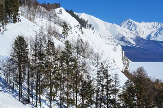 Baikal mountains in winter in snow. Forest in snow-covered mountains.