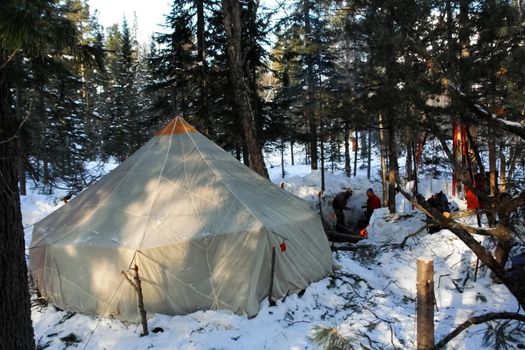 A large tourist tent in the winter forest.