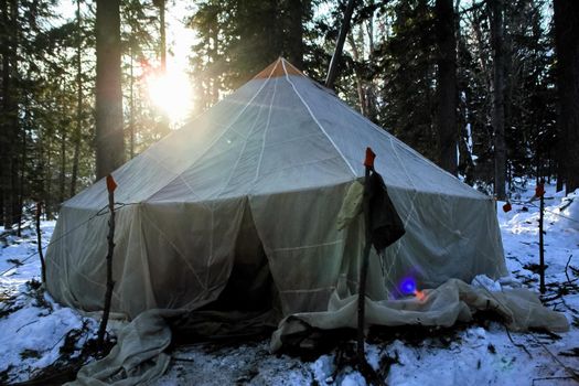 A large tourist tent in the winter forest.