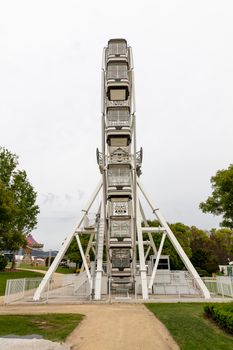 A large white ferris wheel with no people in a public park