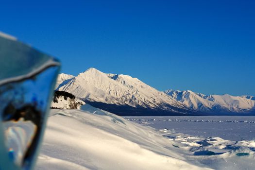 The winter landscape of Lake Baikal. Beautiful mountains in the snow and sky