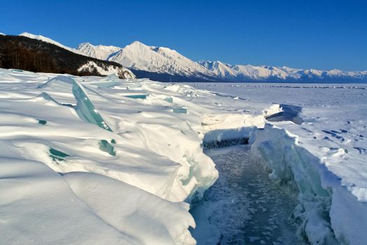 The winter landscape of Lake Baikal. Beautiful mountains in the snow and sky