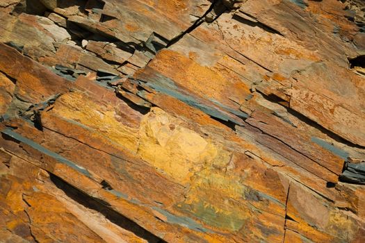 Reddish layered rock wall, with visible geological strata in the Andes mountains.