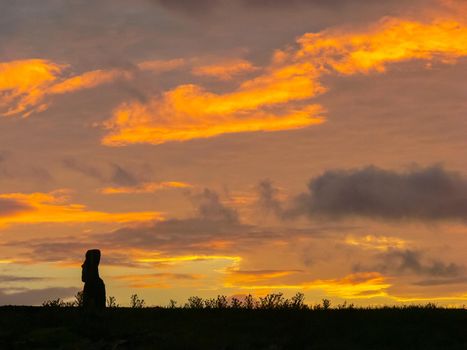 Statues of Easter Island in the background of the sunset. The melting of the Easter statue in the sunlight of the sunset.