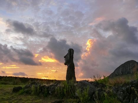 Statues of Easter Island in the background of the sunset. The melting of the Easter statue in the sunlight of the sunset.