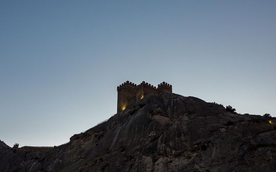 Genoese fortress on a high cliff on the Black Sea coast in Sudak in the late evening.