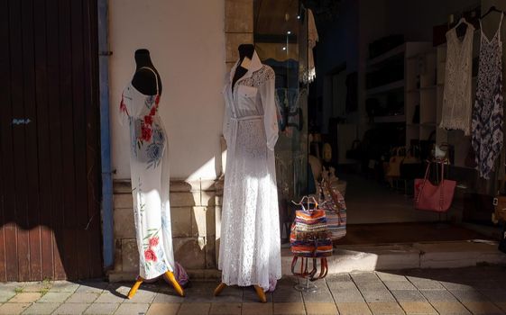 April 22, 2019, Limassol, Cyprus. Mannequins in women's dresses at the entrance to a store on a quiet tourist street.