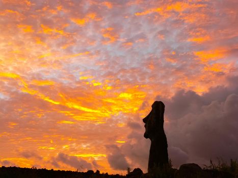 Statues of Easter Island in the background of the sunset. The melting of the Easter statue in the sunlight of the sunset.