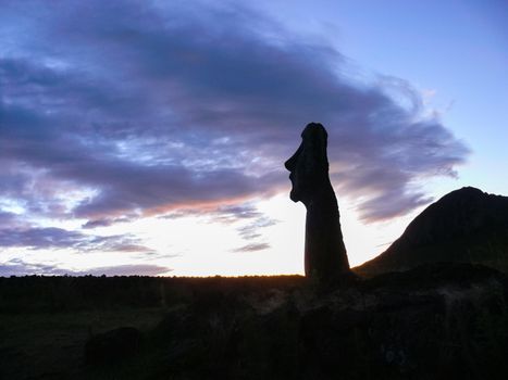 Statues of Easter Island in the background of the sunset. The melting of the Easter statue in the sunlight of the sunset.