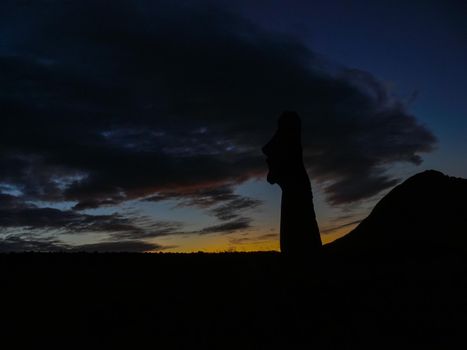 Statues of Easter Island in the background of the sunset. The melting of the Easter statue in the sunlight of the sunset.