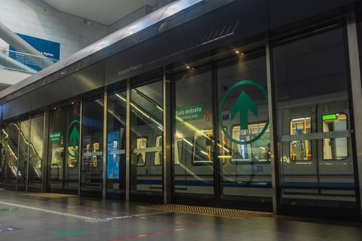 Inside view of the Brescia metro: a train leaving from Marconi station. On the Brescia subway you travel with the new rules dictated by the coronavirus emergency. It is necessary to follow a direction indicated by arrows in and out, green for permitted entrances, red for forbidden ones