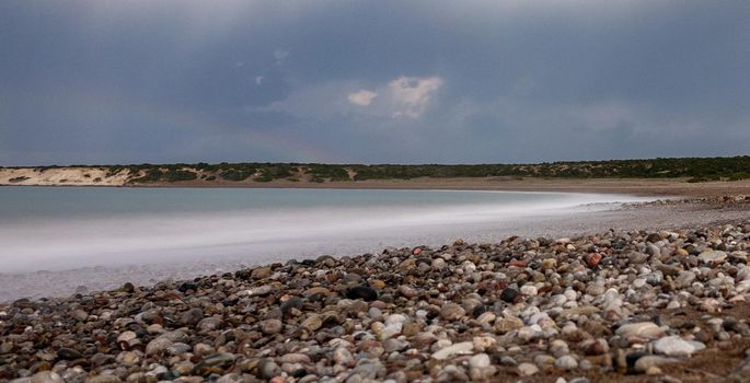 Sandy and pebble beach of the Mediterranean Sea, shot in calm weather at night with a long exposure.