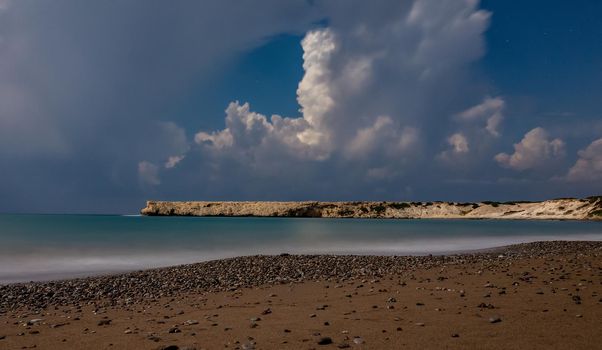Sandy and pebble beach of the Mediterranean Sea, shot in calm weather at night with a long exposure.