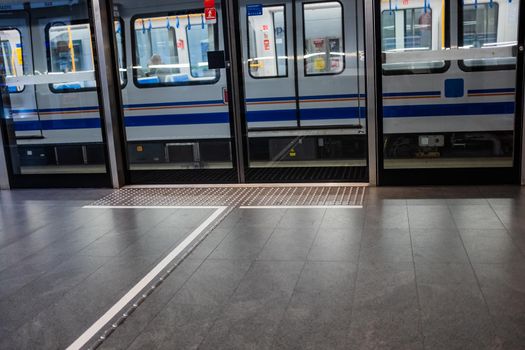 Brescia, Lombardy/Italy: a train leaving from Europa Station on the Brescia Metro. The platform is equipped with screen doors and tactile ground surface indicators as a guide to help visually impaired or blind pedestrians reach the positions of the train access doors.