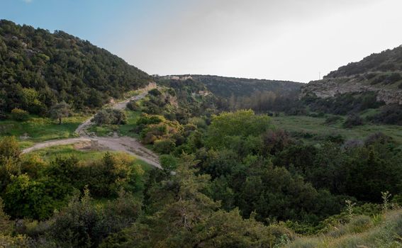 Sandy mountain road of the island of Cyprus in the light of the setting sun.