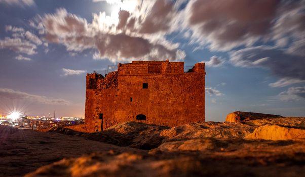 Medieval castle on the shores of the Mediterranean Sea in Paphos city on the island of Cyprus in the light of the full moon.