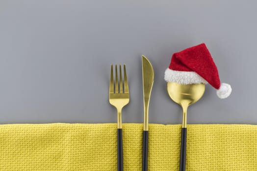 Set of stylish black and gold cutlery on a two tone grey and yellow background with copy space viewed as a flat lay. Main color trend of the year