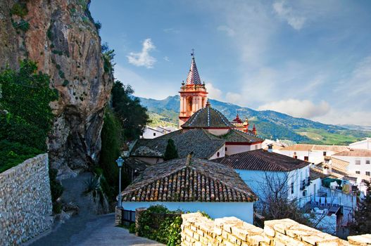 Roofs of the houses and roof of the Cathedral,mountain with trees, sunny day, Spain