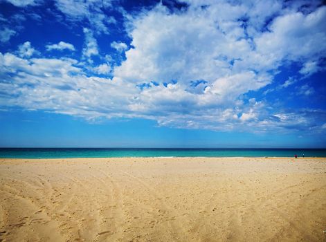 Amazing view of the emerald sea, yellow sand and blue sky with clouds, spring, Spain