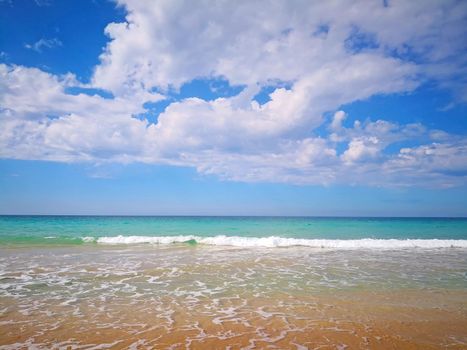 Seashore with waves, blue water and blue sky with the clouds, summer, Spain