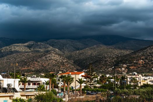 Beautiful shot of a tropical town with cloudy hills in the distance