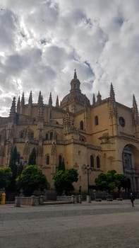 Vertical shot of the majestic Segovia Cathedral on the cloudy sky background